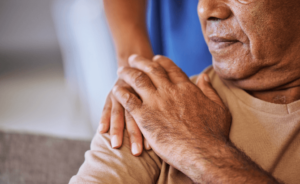 A caregiver puts their hand on the shoulder of a mesothelioma patient to comfort them